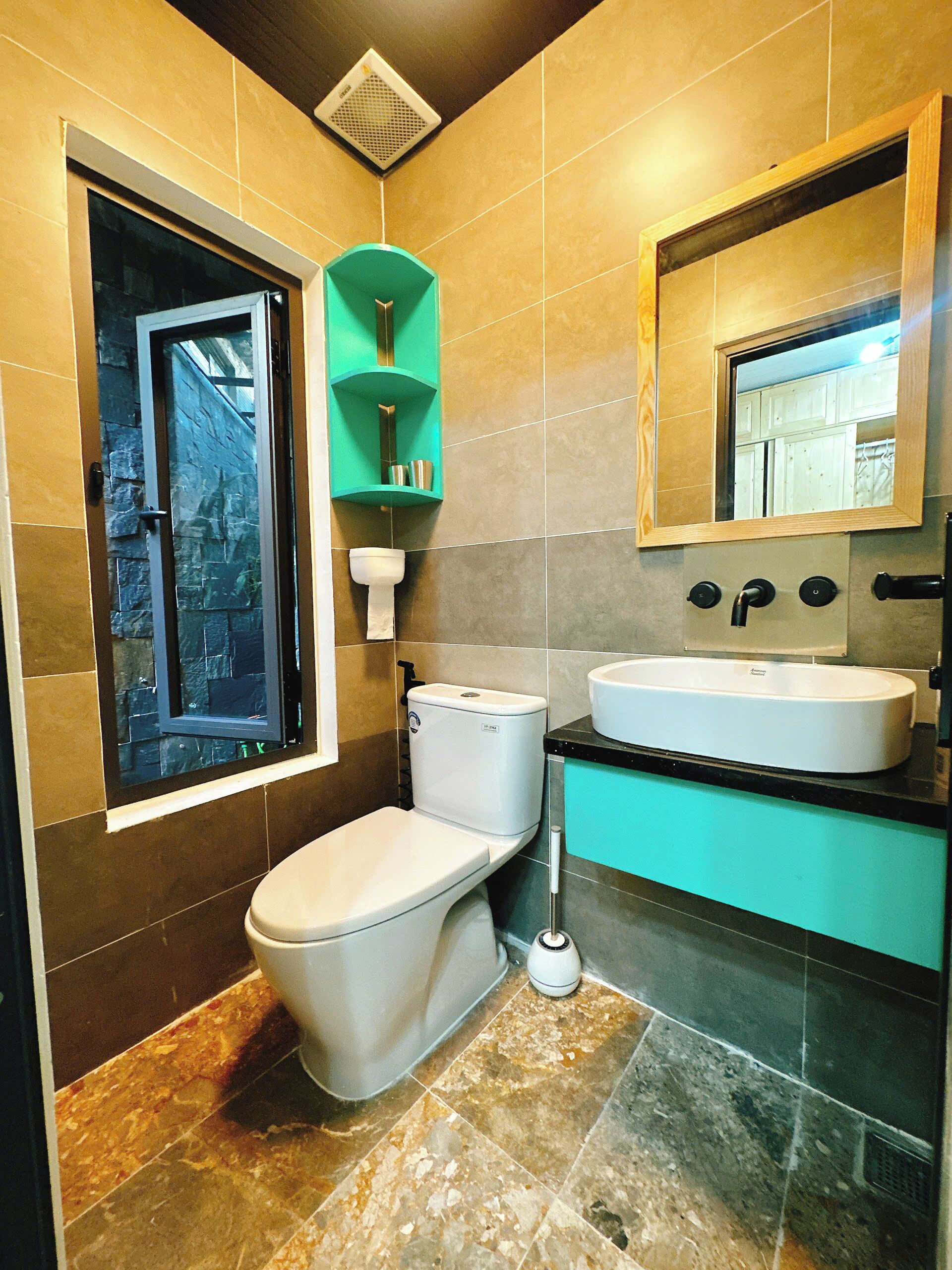 A modern bathroom with a toilet, sink, and a window.