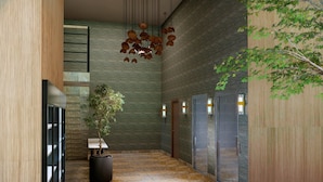 A modern interior with a marble floor, a potted plant, a hanging light fixture, and a wall-mounted elevator.