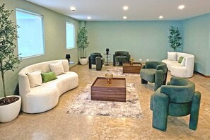 A spacious living room with a sofa, armchairs, a coffee table, and potted plants. - Wyndham Garden Durango (Durango)
