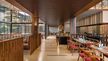 Un restaurante moderno con una barra larga, separadores de madera y una variedad de opciones de asientos.