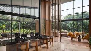 A modern office space with a glass wall overlooking a lush garden.