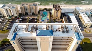 A high-rise hotel with multiple balconies, a swimming pool, and a beach view. - Crystal Tower 1703 (Gulf Shores)