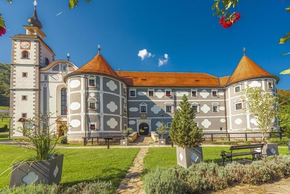 A historic building with a central courtyard, a bell tower, and a symmetrical facade with white and gray patterns.