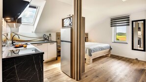 Una cocina moderna con horno empotrado, refrigerador y un comedor con mesa y sillas.