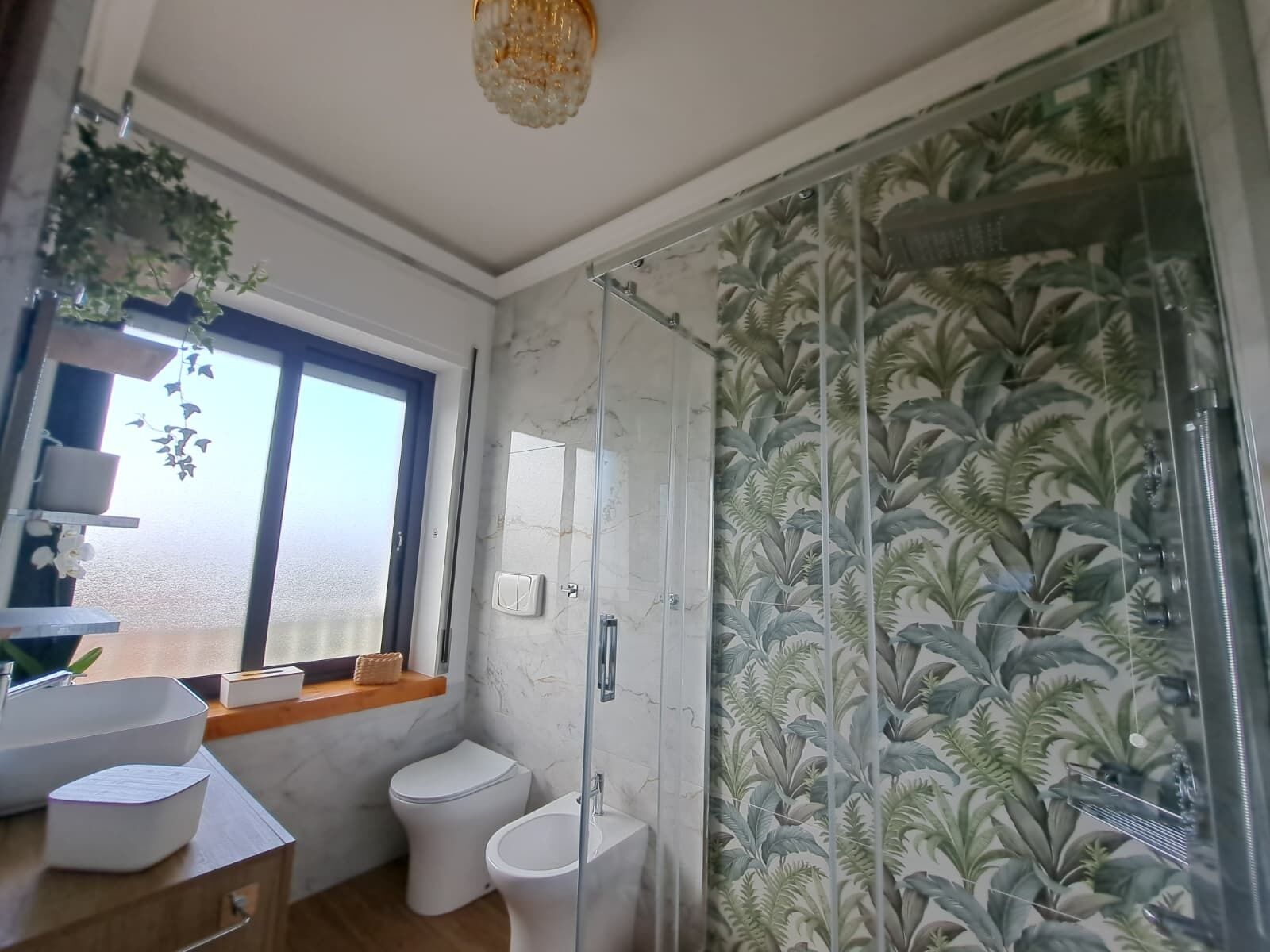 Une salle de bain moderne avec une douche à parois de verre, des toilettes et un lavabo.