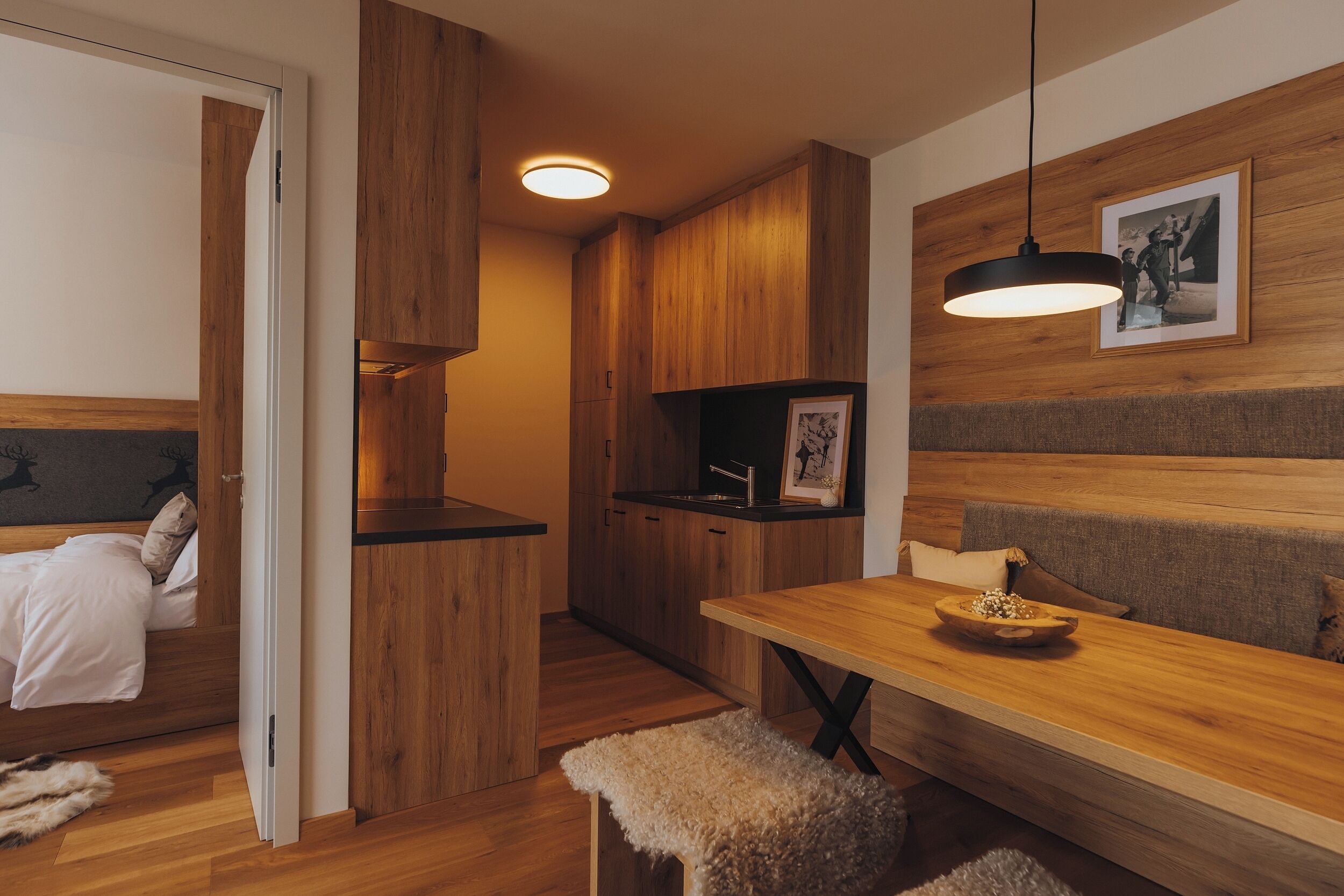 Un espacio habitable moderno y compacto con interior de madera, comedor y kitchenette.