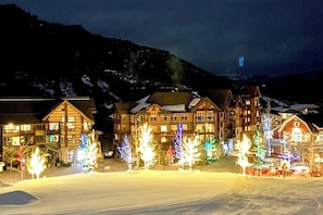 A hotel with multiple buildings, a snow-covered ground, and a mountainous backdrop.