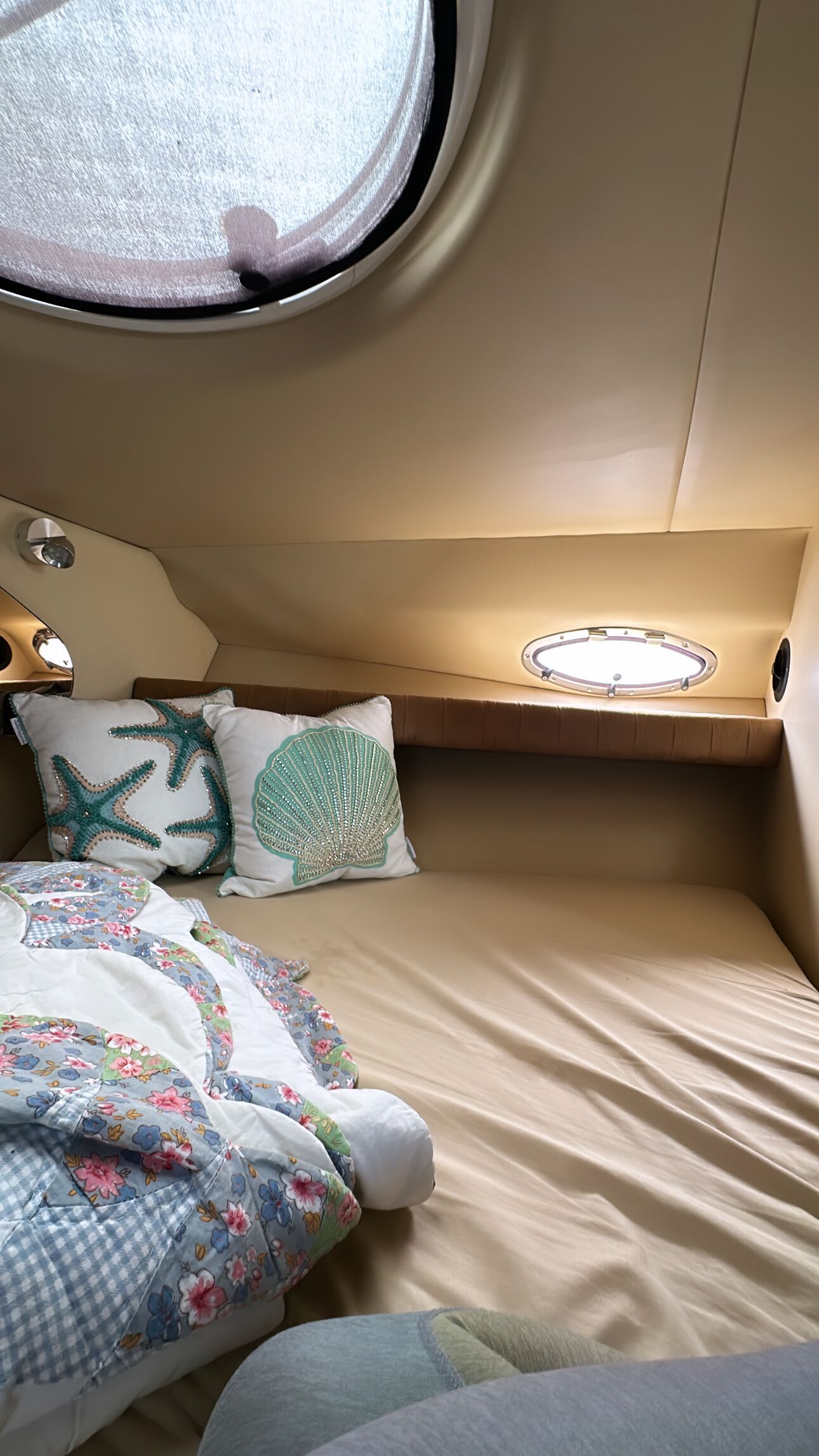 Ein gemütliches Blockhauszimmer mit Bett, Kissen, einem kleinen Fenster und einer Ablage.