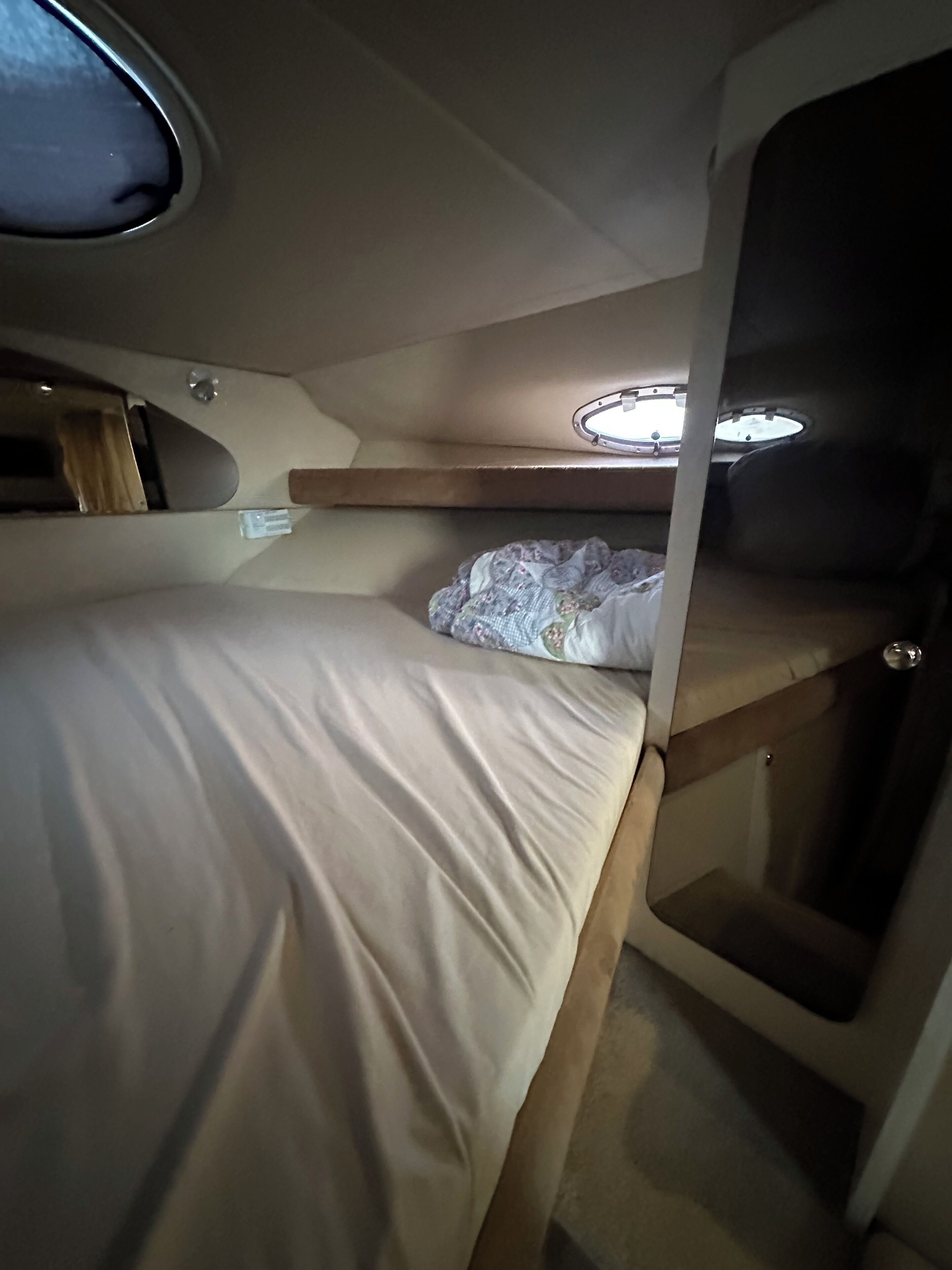 Une cabine compacte et bien éclairée, équipée d’un lit superposé, d’une petite table et d’une fenêtre donnant sur un paysage agréable.