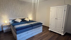 A bedroom with a bed, nightstands, and a wardrobe.