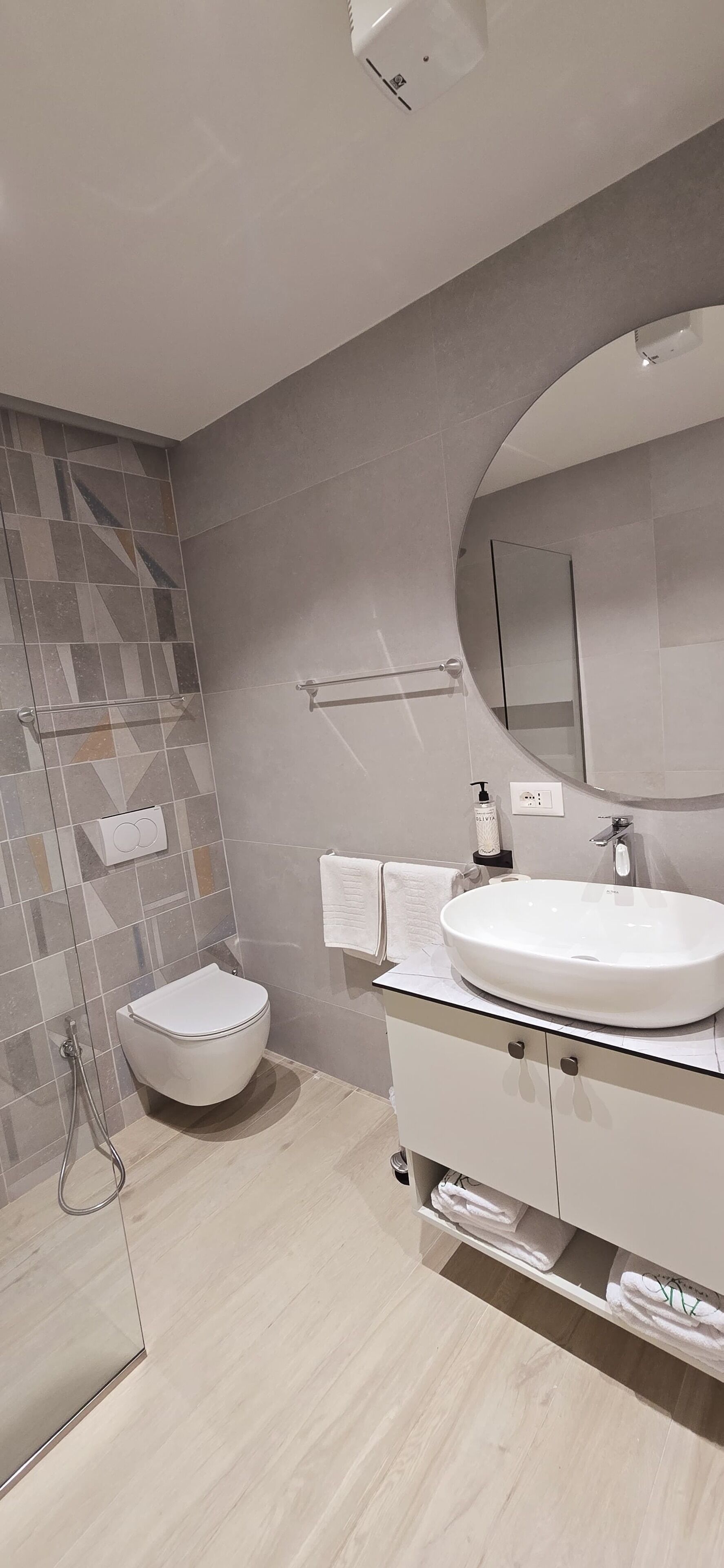 A modern bathroom with a toilet, sink, and shower.