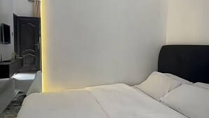 Une chambre d’hôtel moderne dotée d’un grand lit, d’un téléviseur à écran plat fixé au mur et d’un petit espace bureau.