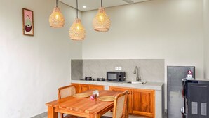 Une cuisine moderne avec une table à manger en bois, un four à micro-ondes et un réfrigérateur.