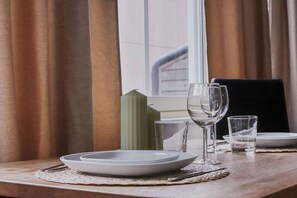 Une table à manger dressée avec des assiettes, des verres et une bougie.