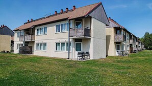 A multi-story residential building with balconies, a flat roof, and a grassy lawn. - GotlandStay Volontären (Visby)