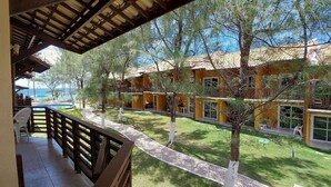 Un patio con piscina, mobiliario exterior y vista al océano.