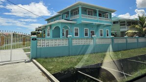 A two-story building with a balcony, a gated entrance, and a number "43" sign. - DougVille 43
 Tranquillity and Peace await! (Venezuela Scheme)