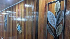 A wooden wall with vertical planks, a sunburst mirror, and a framed leaf decoration. - DougVille 43
 Tranquillity and Peace await! (Venezuela Scheme)