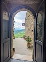 Un arco de entrada que da a un balcón con vistas a un paisaje montañoso.