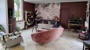 A living room with a sofa, armchair, and a television. - Gîte L'instant Ressource in the heart of Puisaye-Forterre (Villiers-Saint-Benoît)