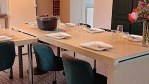 A dining area with a long table set for four, equipped with plates, cutlery, and wine glasses. - Gîte L'instant Ressource in the heart of Puisaye-Forterre (Villiers-Saint-Benoît)