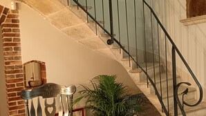 A staircase with a black metal railing, a potted plant, and a wooden chair. - Gîte L'instant Ressource in the heart of Puisaye-Forterre (Villiers-Saint-Benoît)