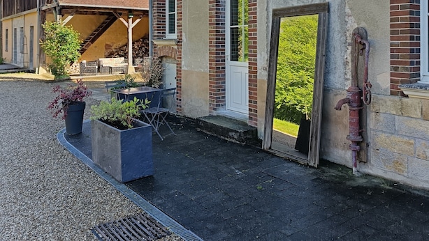 A building with a brick facade, a wooden structure to the left, and a metal door frame. - Gîte L'instant Ressource in the heart of Puisaye-Forterre (Villiers-Saint-Benoît)