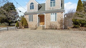 A two-story house with a front porch, a garage, and a driveway.