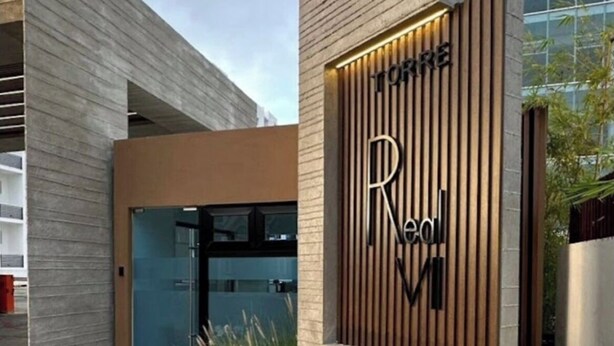 Un edificio moderno con un letrero que dice "TORRE Real Mi".