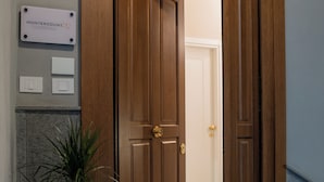 A wooden door with a doormat labeled "Monteroduni 22" leading to a room with a checkered floor. - Monteroduni 22 - Chiaia Design Rooms (Naples)