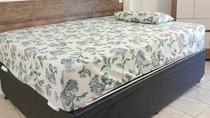 A bedroom with a bed, a wardrobe, and three framed pictures on the wall. - APARTMENT ACONCHEGO, NEXT TO NORTH SHOPPING AND DOWNTOWN MARACANAU (Jereissati II Maracanaú)