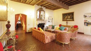 A traditional living room with a fireplace, a dining table, and a bookshelf.