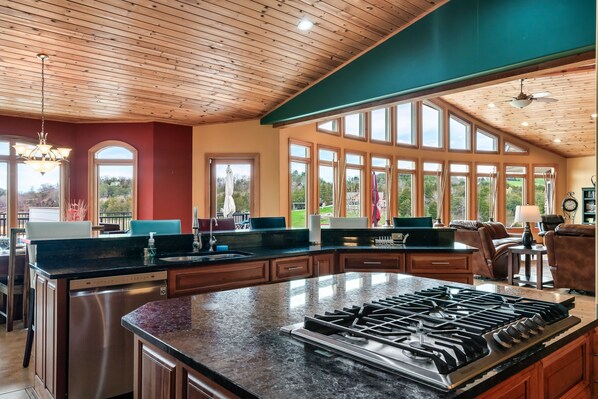 A spacious kitchen with a large island, wooden ceiling, and large windows offering a view of the outdoors. - Lakefront - Pool & Dock. 10+Private acres. (Dandridge)