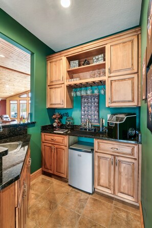 A compact kitchen with wooden cabinets, a built-in coffee machine, and a window with a view. - Lakefront - Pool & Dock. 10+Private acres. (Dandridge)