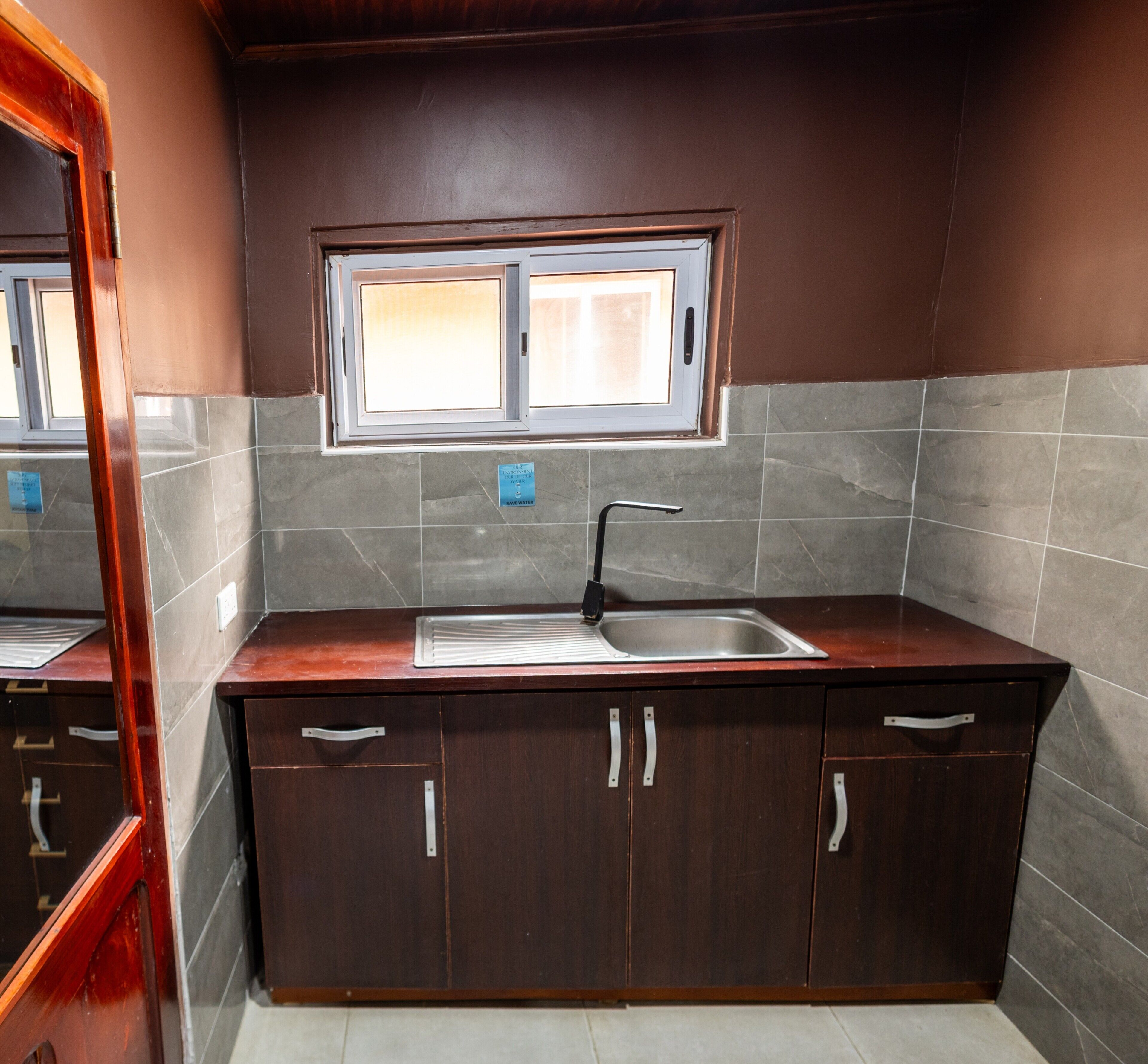 A kitchen with a built-in sink, cabinets, and a window above the sink.