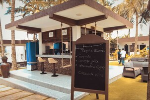 An outdoor bar area with a chalkboard menu listing drinks and a bar counter.