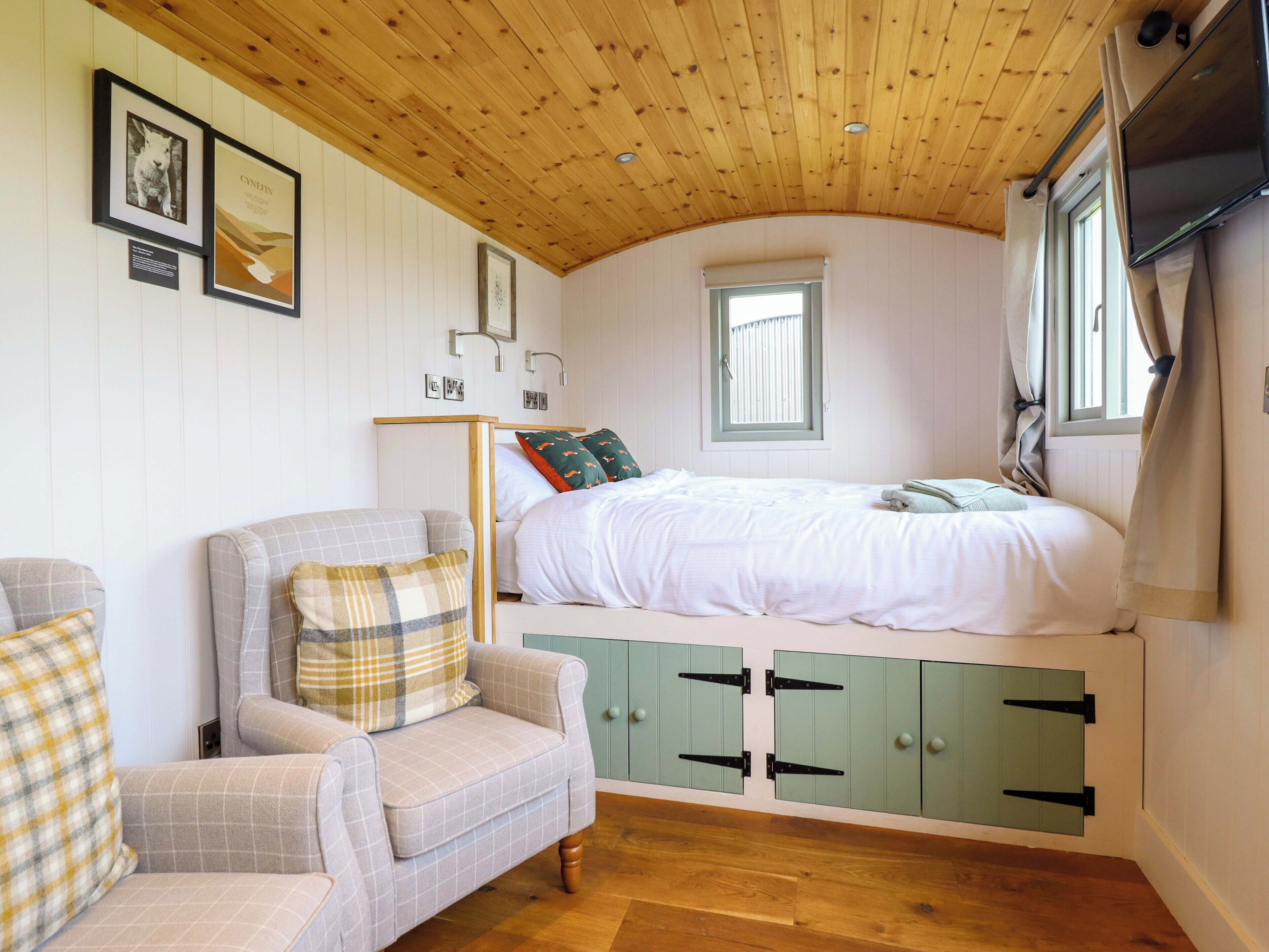 Ein gemütliches Schlafzimmer mit Bett, Stuhl und Fenster.
