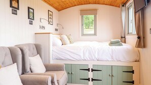 Ein Schlafzimmer mit Bett, Sofa, Fenster und Fernseher.