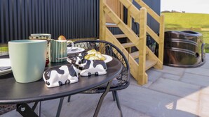 A table with a mug, a striped mug, a jar, a croissant, and two cow-shaped coasters. - Defaid Cymreig (Oswestry)