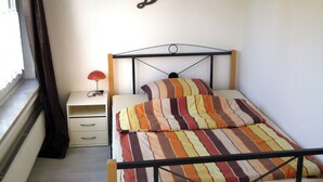A bedroom with a bed, a nightstand, a lamp, and a wall with the word "Dream" written on it. - Vacation apartments on the Lesum - FeWo Lesmona - TOP long-term conditions (Bremen)