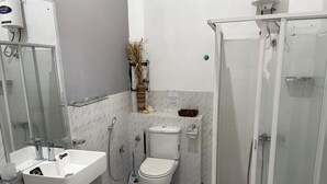 A bathroom with a toilet, sink, and shower.