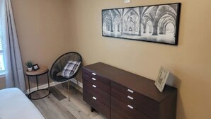 A hotel room with a bed, a small round table with a chair, a dresser, and a framed picture on the wall. - Cheerful 2 bedroom 2bath townhouse (14hv) (Columbia)