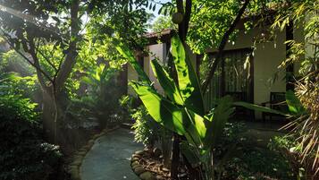 Un sendero de jardín que conduce a un edificio con techo de tejas y una pared de piedra.