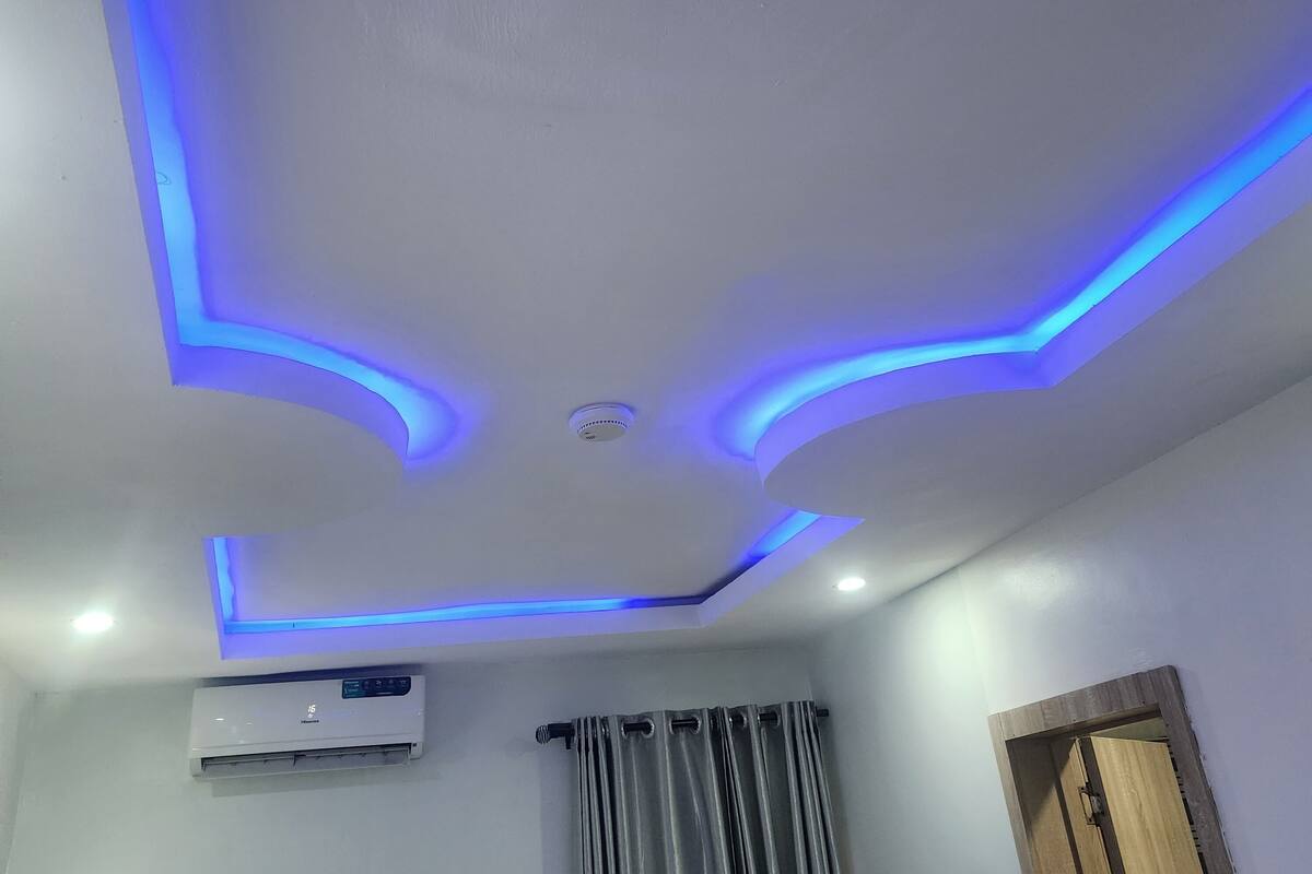 A room with a white ceiling featuring blue LED lighting along the edges.