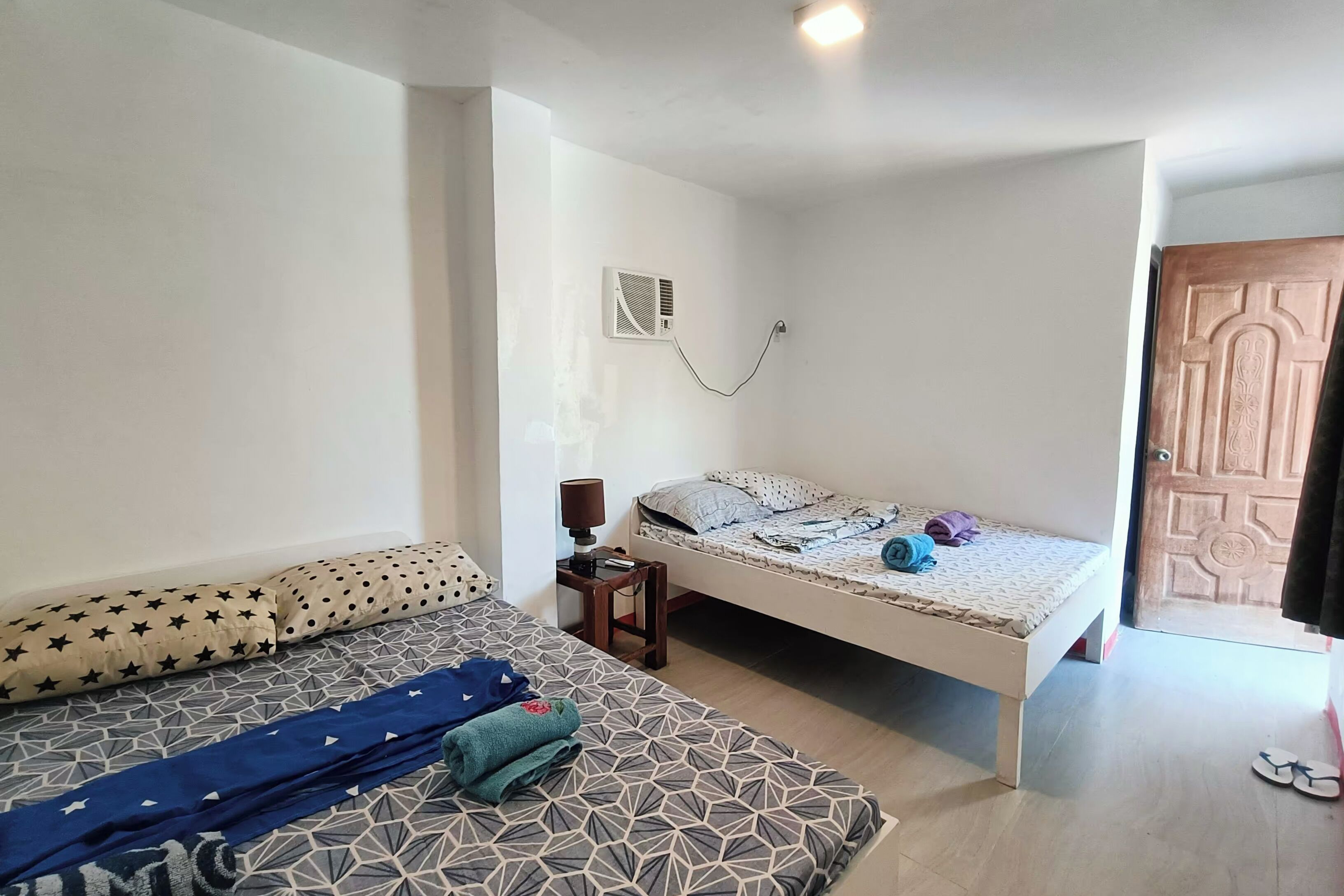 Un dormitorio con cama, sofá, mesita de noche con lámpara y armario.