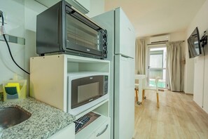 A compact kitchenette with a microwave, toaster, and a small sink.