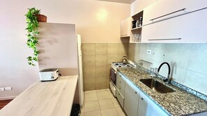 A compact kitchen with a toaster, a kettle, and a sink. - Luxury Apartment in Belgrano (Buenos Aires)