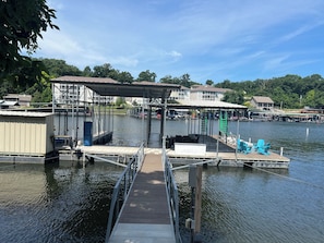 A dock with a covered seating area, a lifeguard stand, and a small building. - Gentle lot and unbeatable location.  No wake, deep water,big slip, and huge dock (Sunrise Beach)