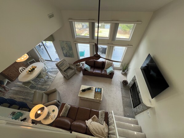 A spacious living area with a large window, a fireplace, and a television mounted on the wall. - Gentle lot and unbeatable location.  No wake, deep water,big slip, and huge dock (Sunrise Beach)