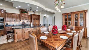 A spacious kitchen with wooden cabinets, a large island, and a dining area with a wooden table set for six. - Lakefront - Unbelievable 3 levels w/Elevator! (Dandridge)